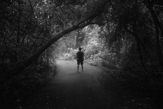 person standing alone in forest, black and white